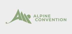 Na fotografiji je logotip, kjer je na levi strani velika tiskana črka A napisana tako, da sta za njo postavljena še dva trikotnika in tako formirajo hribovje. Desno piše Alpine Convention